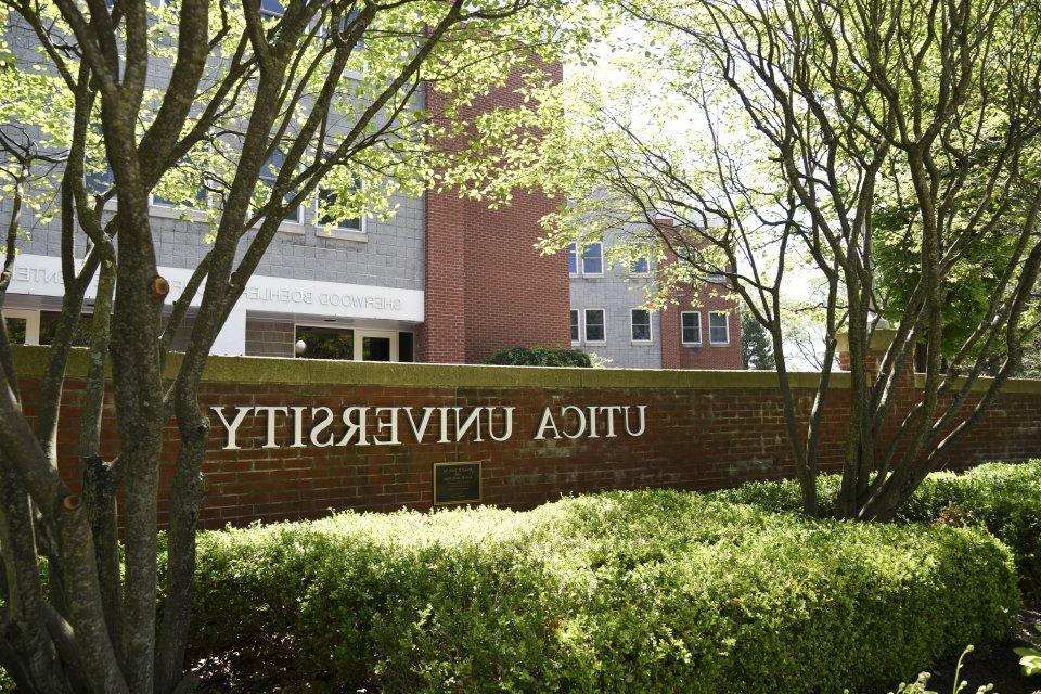 The words 利记sbo against a brick wall in front of a residence hall.